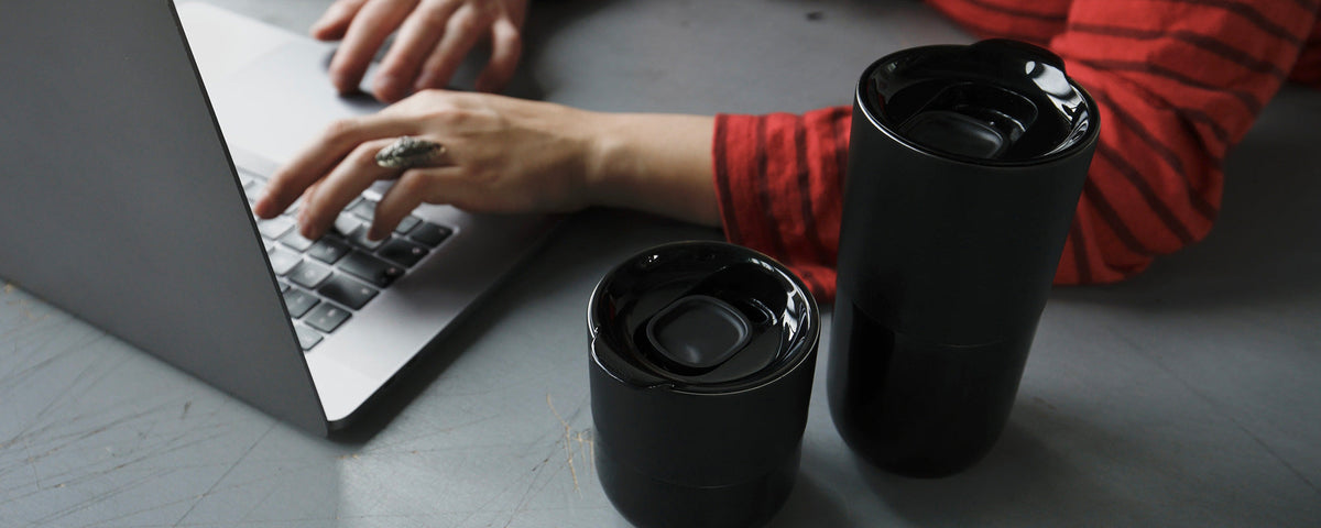Klean Kanteen black drinkware beside a laptop